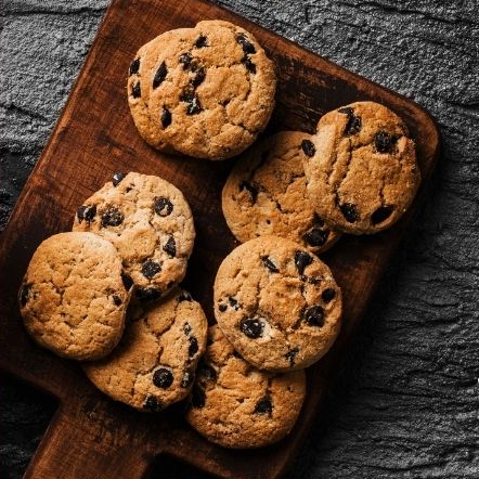 Freshly baked cookies sitting on a wooden board