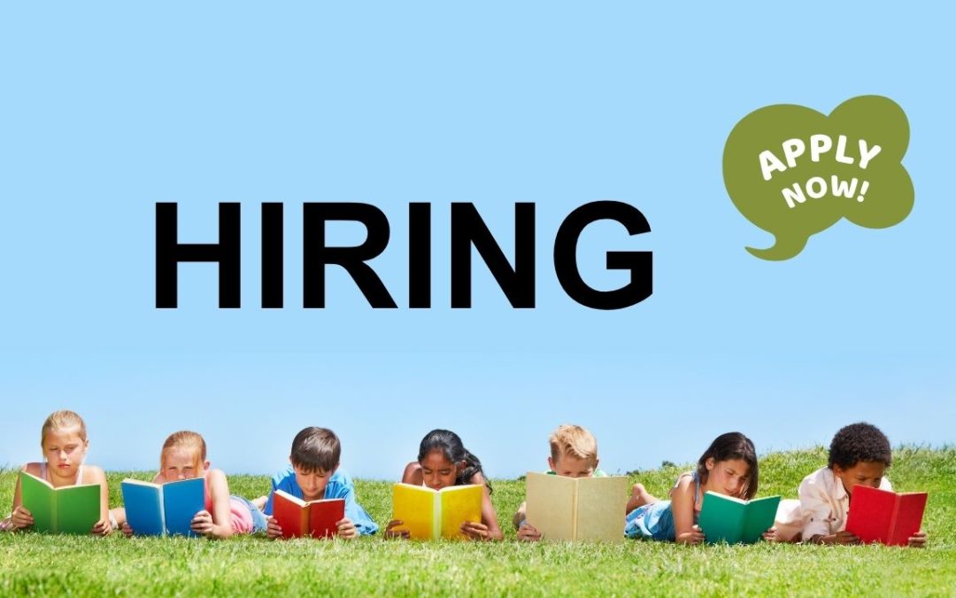 Five children lying on grass, reading colorful books, with "HIRING" in bold black letters and a green speech bubble saying "APPLY NOW!"